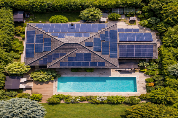 een huis met zonnepanelen op het dak om het zwembad te verwarmen